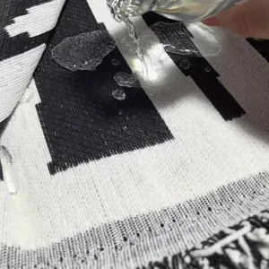 Detailaufnahme des wasserdichten Chenille-Sofabezugs mit Wassertropfen auf Schwarz-Weiß-Stoff