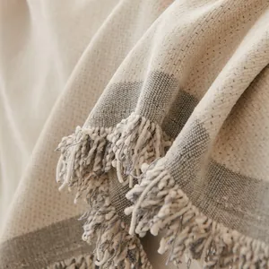 Housse de canapé en chenille beige avec rayures grises et pompons de style bohème