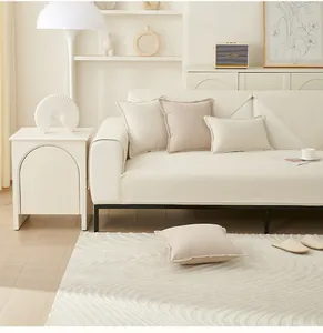 Detailaufnahme des wasserdichten Sofabezugs mit passenden Kissen in Beige und Crème