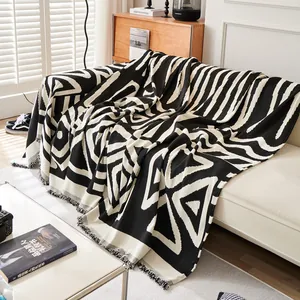 Bohemian black and white geometric chenille sofa cover with fringed edges in modern room