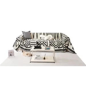 Chenille sofa throw cover with black and white geometric patterns and tassel edges
