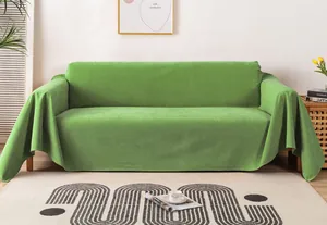 Close-up of waterproof green corduroy sofa cover draped over a modern sofa in a home setting