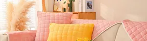 Dettaglio del copridivano in peluche trapuntato rosa e giallo con motivo goffrato quadrato