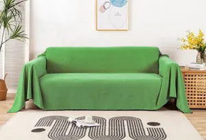 Dettaglio del copridivano in velluto verde brillante con elegante bordo strutturato nero e bianco