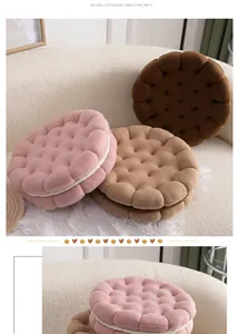 Detail of soft biscuit-shaped cushions in pink and brown on a white sofa setting
