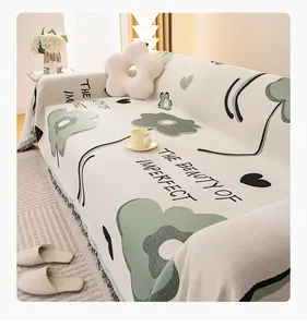 Dettaglio del copridivano in ciniglia con motivi floreali e frange nere decorative