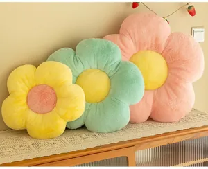 Détail de coussins en peluche en forme de fleurs jaunes, vertes et roses douces