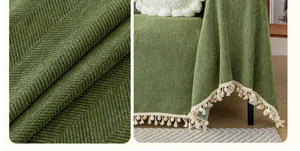 Detail of forest green chenille sofa cover with herringbone pattern and colorful pom-poms