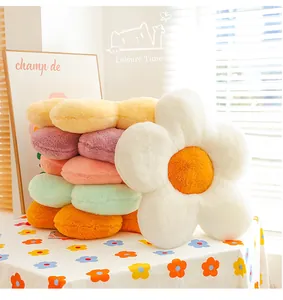 Détail d'un coussin moelleux en forme de tournesol avec pétales blancs et centre orange