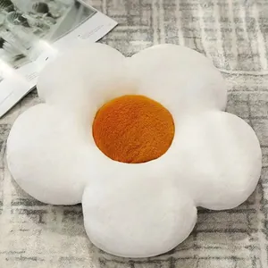 Coussin en peluche marguerite blanche avec centre jaune sur un tapis gris chic