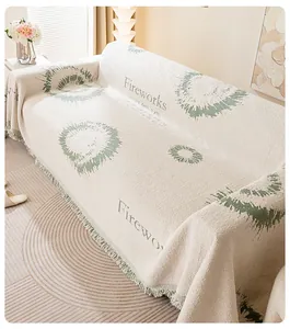 Détail de la housse de canapé en chenille blanc crème avec motifs verts et franges