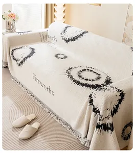 Détail de jeté de canapé blanc crème avec motifs de feux d'artifice noirs et bords à franges
