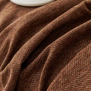 Close-up of brown chenille sofa cover showing herringbone texture and thick fabric detail