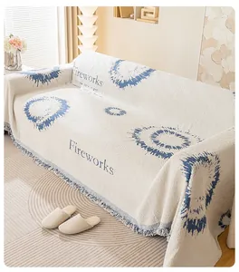 Détail du jeté de canapé en tricot blanc crème avec motif feu d'artifice bleu et franges