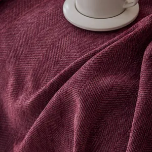 Macro view of burgundy herringbone chenille fabric with a white ceramic coffee cup