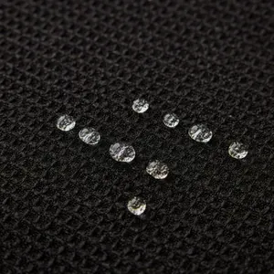 Funda de sofá negra con textura de gofre impermeable y gotas de agua