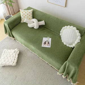 Modern chenille sofa cover in grass green with stylish pom-pom fringe and herringbone texture