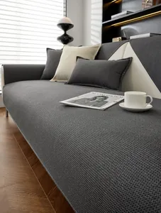 Détail de la housse de canapé gris foncé gaufrée et du coussin assorti dans le salon