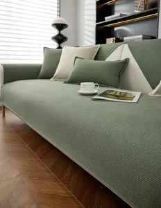 Détail de la texture gaufrée verte de la housse de canapé avec bordure contrastée crème