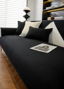 Détail de coussin de canapé gaufré noir avec surpiqûres blanches et oreillers assortis