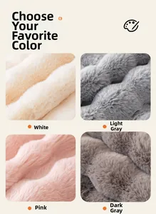 Detail of plush faux rabbit fur sofa cushions in white, light grey, pink, and dark grey