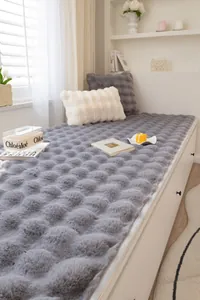 Detalle de la alfombra gris de piel de conejo sintética con textura 3D y cojines de felpa
