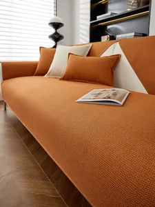 Détail de la housse de canapé orange à texture gaufrée et coussins moelleux assortis