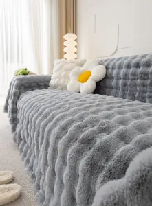 Close-up of gray plush sofa cover with thick wave texture and soft velvet finish