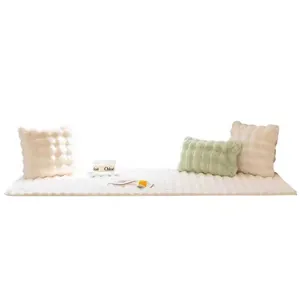 Alfombra de felpa color crema con textura de conejo y cojines decorativos a juego