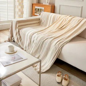 Gestreifte creme-beige Sofa-Überwurfdecke mit handgefertigten Fransen auf einem Sofa