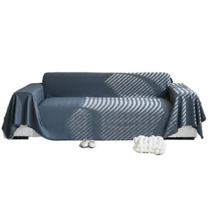 Copridivano blu navy con trama a rombi su divano bianco con eleganti effetti di luce