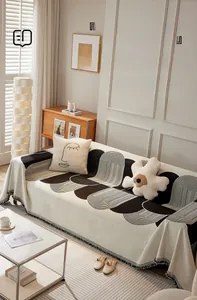 Détail de la housse de canapé en chenille avec lignes géométriques et bordures frangées