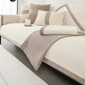 Detail of chenille sofa cushion showing woven texture and tweed border trim in beige