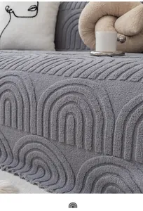 Detail eines grauen Plüsch-Sofabezugs mit Regenbogenwellen-Textur und Fransenrand