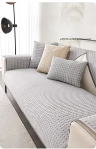 Close-up of light grey cooling sofa mat with diamond quilted texture on a beige sofa