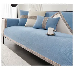Detail of light blue chenille sofa cushion with gray woven fringe and matching pillow