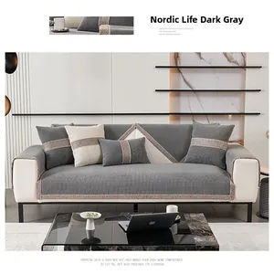 Detail of dark gray chenille sofa cover with woven lace edges on a modern couch