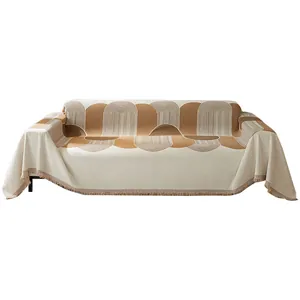 Housse de canapé en chenille beige et fauve avec motifs géométriques et bord frangé
