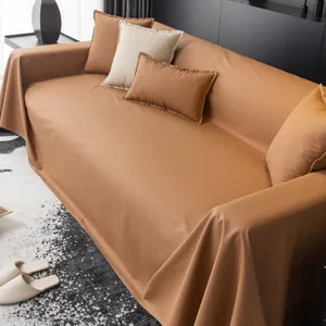 Detail view of the modern brown leather-texture waterproof sofa cover on a dark couch