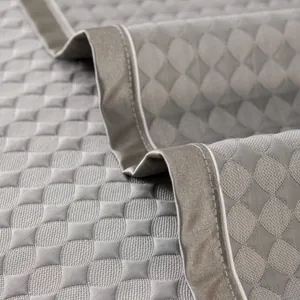 Cooling gray quilted sofa mat with breathable fabric and non-slip backing for summer