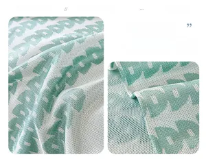 Close-up of breathable green ice silk sofa cover with geometric jacquard cooling fabric