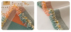 Detail of bohemian chenille sofa cover showing geometric weave and colorful tassels