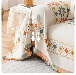 Close-up of bohemian chenille sofa cover with geometric patterns and colorful tassels