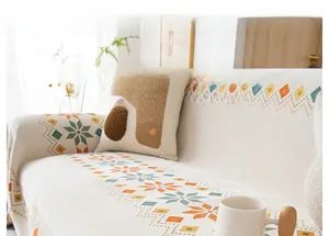 Detail of chenille bohemian sofa cover featuring orange and green geometric star patterns