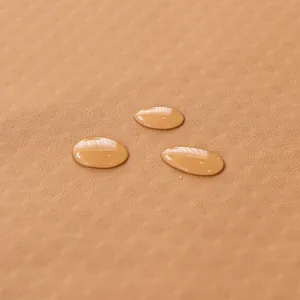 Copridivano impermeabile in pelle color cammello con gocce d'acqua su superficie testurizzata