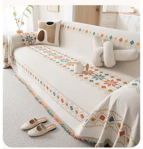 Detail of bohemian chenille sofa cover with colorful geometric patterns and fringe