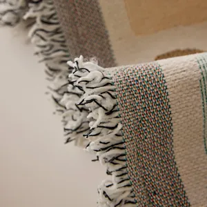 Reversible chenille sofa cover featuring vintage woven texture and tassel fringe details