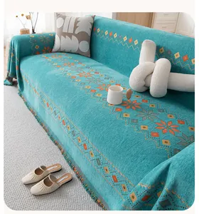 Detail of chenille sofa cover with bohemian geometric jacquard and colorful fringes