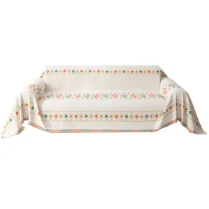 Bohemian chenille sofa cover with orange geometric patterns and tassel edges on white