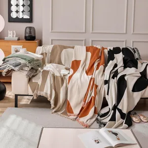 Modern geometric knit sofa cover with fringe, premium cat-proof blanket in warm tones